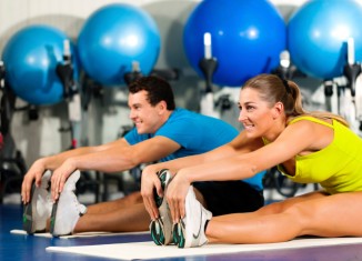 Couple Exercising Stretching at the Gym